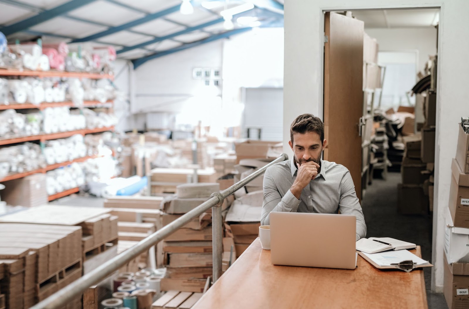 a man in a warehouse working on a laptop